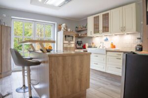 Helle Landhausküche mit Austritt zur Terrasse