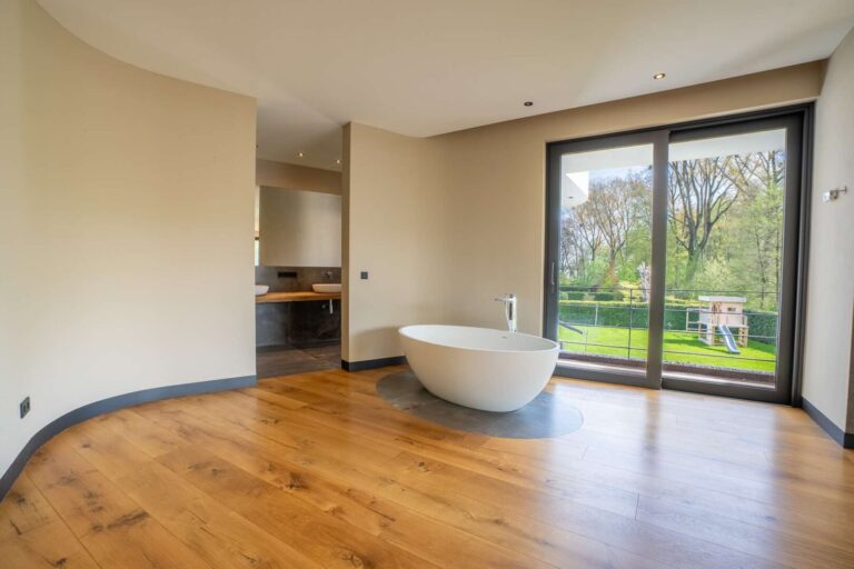 Ankleidebereich mit freistehender Badewanne und Blick zum Bad en Suite (WE1)