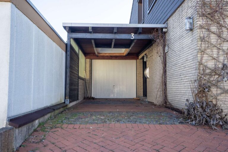 Überdachter Hauseingang und große Garage