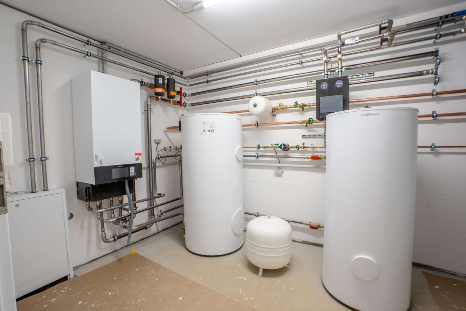 Aufgeräumter Heizungskeller mit Wärmepumpe und Technik